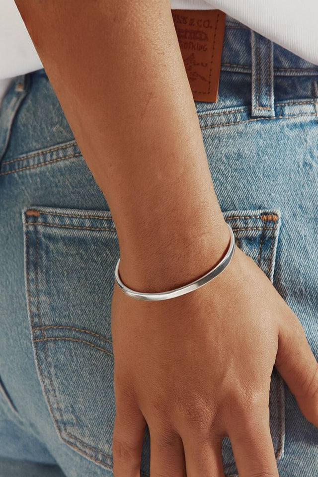 Tjej som bär ett cuff armband i äkta silver till jeans.