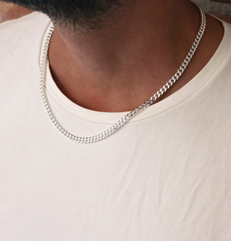 Man som bär ett halsband med 5 mm bred pansarkedja i silver.