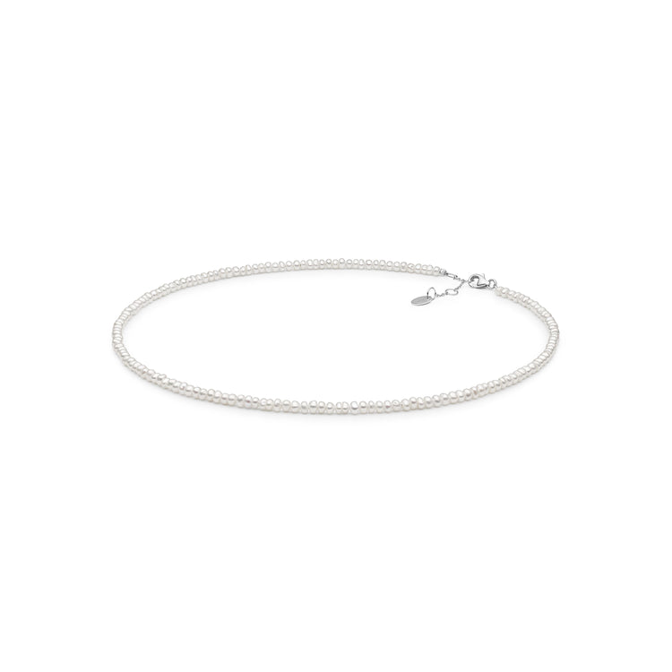 Pärlhalsband med små vita pärlor. Kort choker halsband.