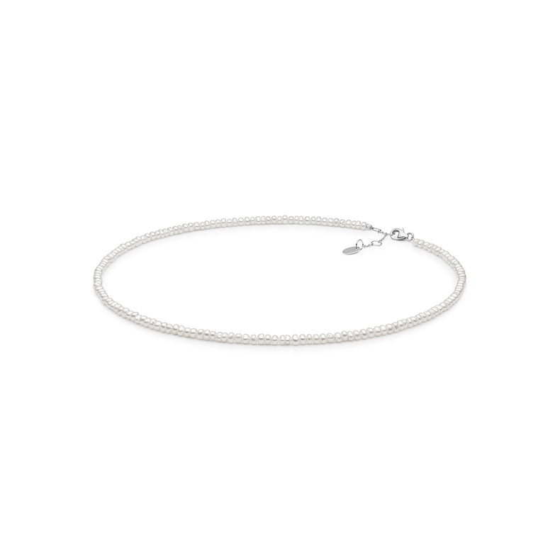 Pärlhalsband med små vita pärlor. Kort choker halsband.