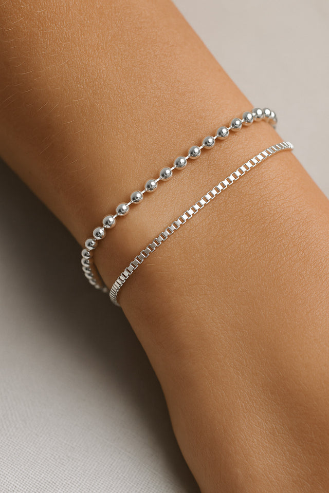 armband med kulkedja i silver kombinerat med ett annat silverarmband.