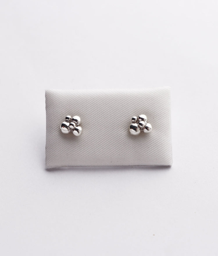 silverörhängen med kulor fästa på en kudde.