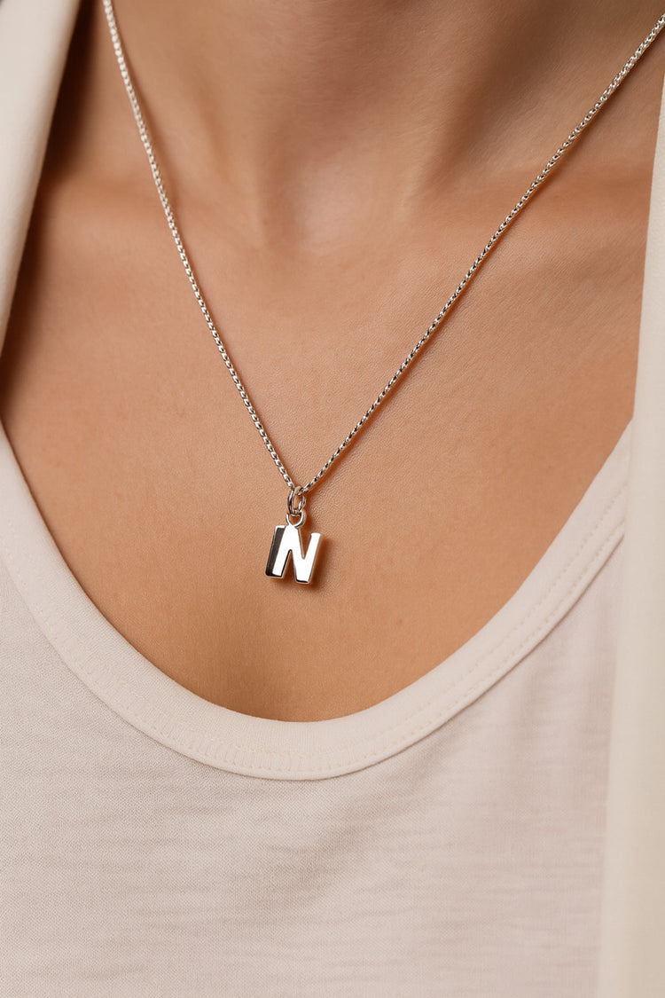Halsband med bokstavsberlock i silver.