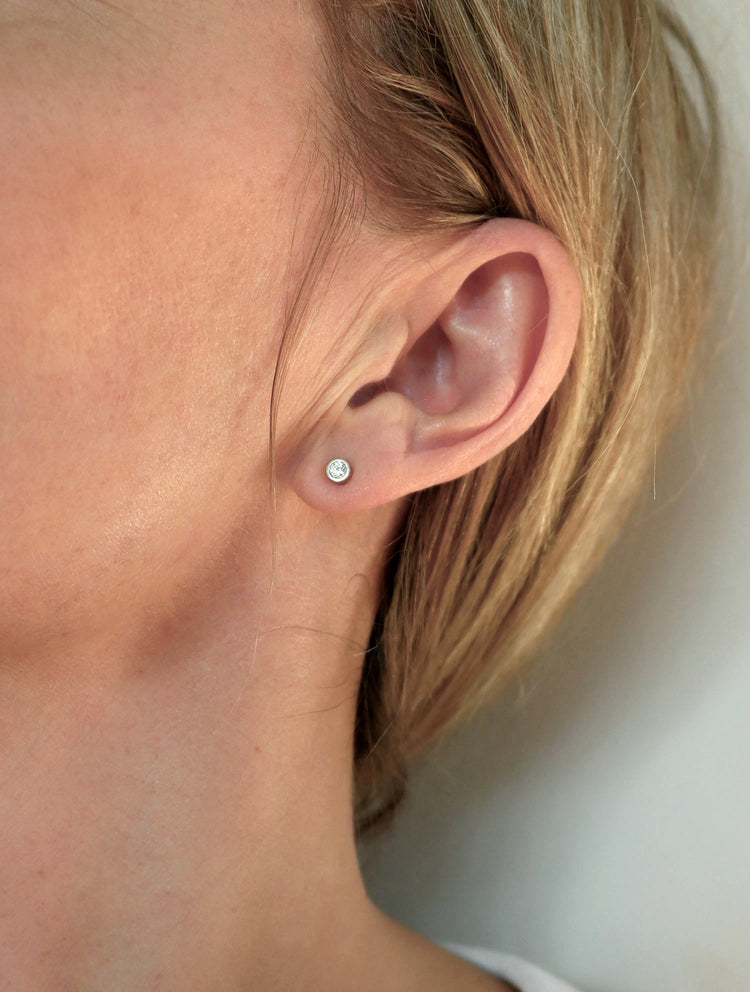 Tjej som bär små diamantörhängen.