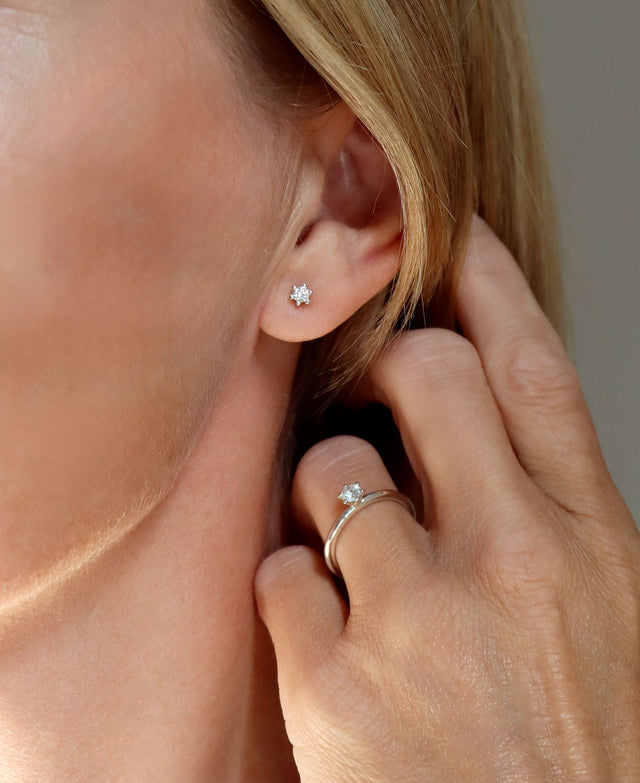 Tjej som bär diamantörhängen och diamantring.