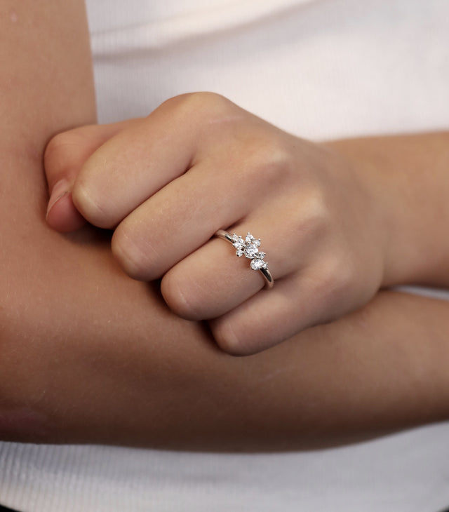 Tjej som bär en ring med flera diamanter i olika storlekar.