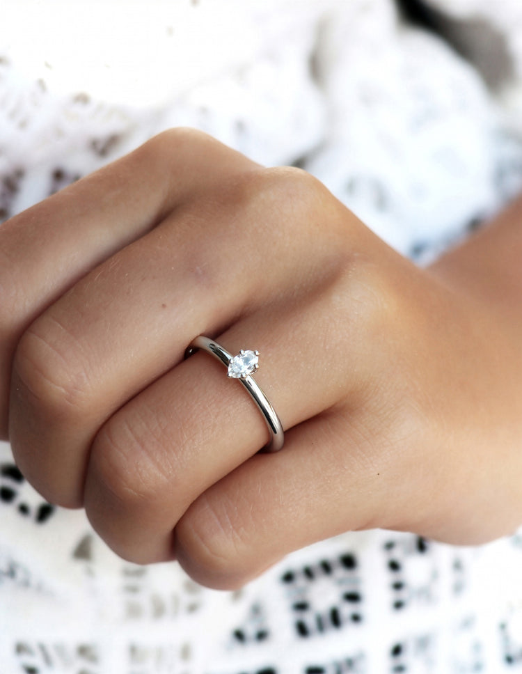 Tjej som bär en förlovningsring i silver med oval diamant 0,25 ct.