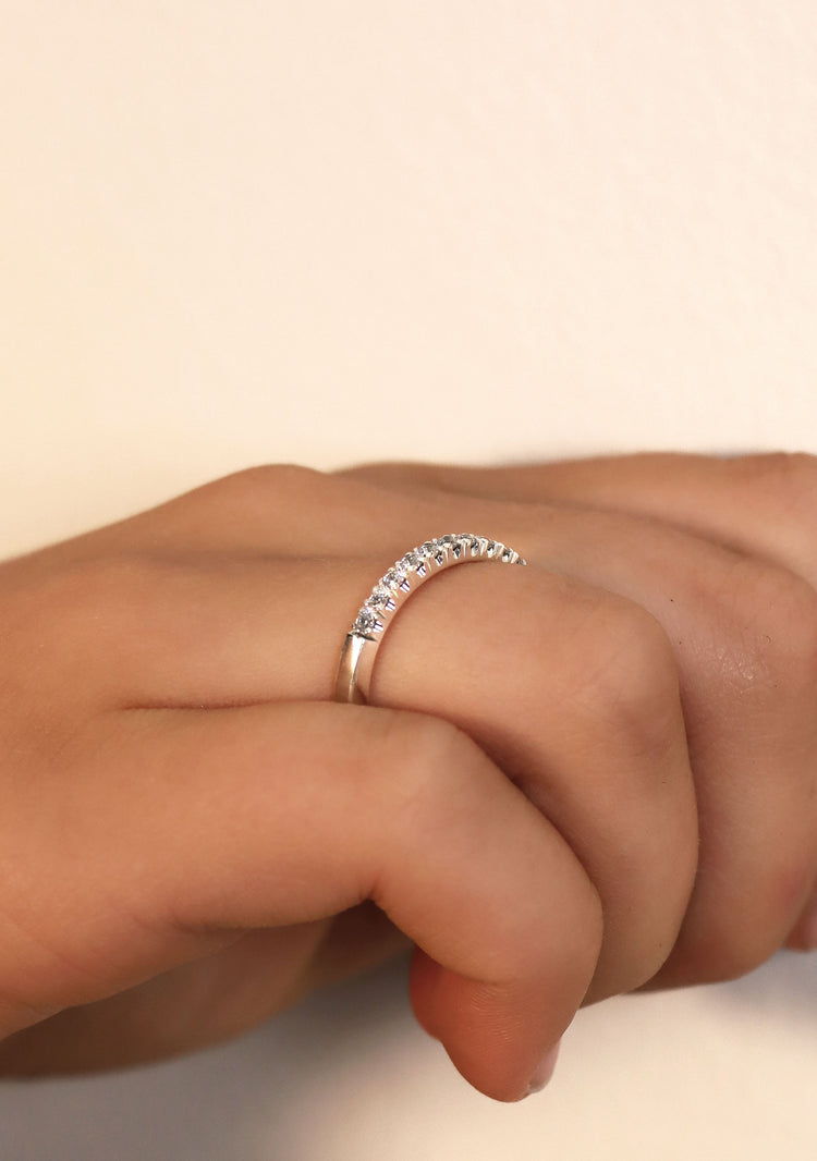 närbild på diamantring som har raka kanter och diamanter infattade i kronor.