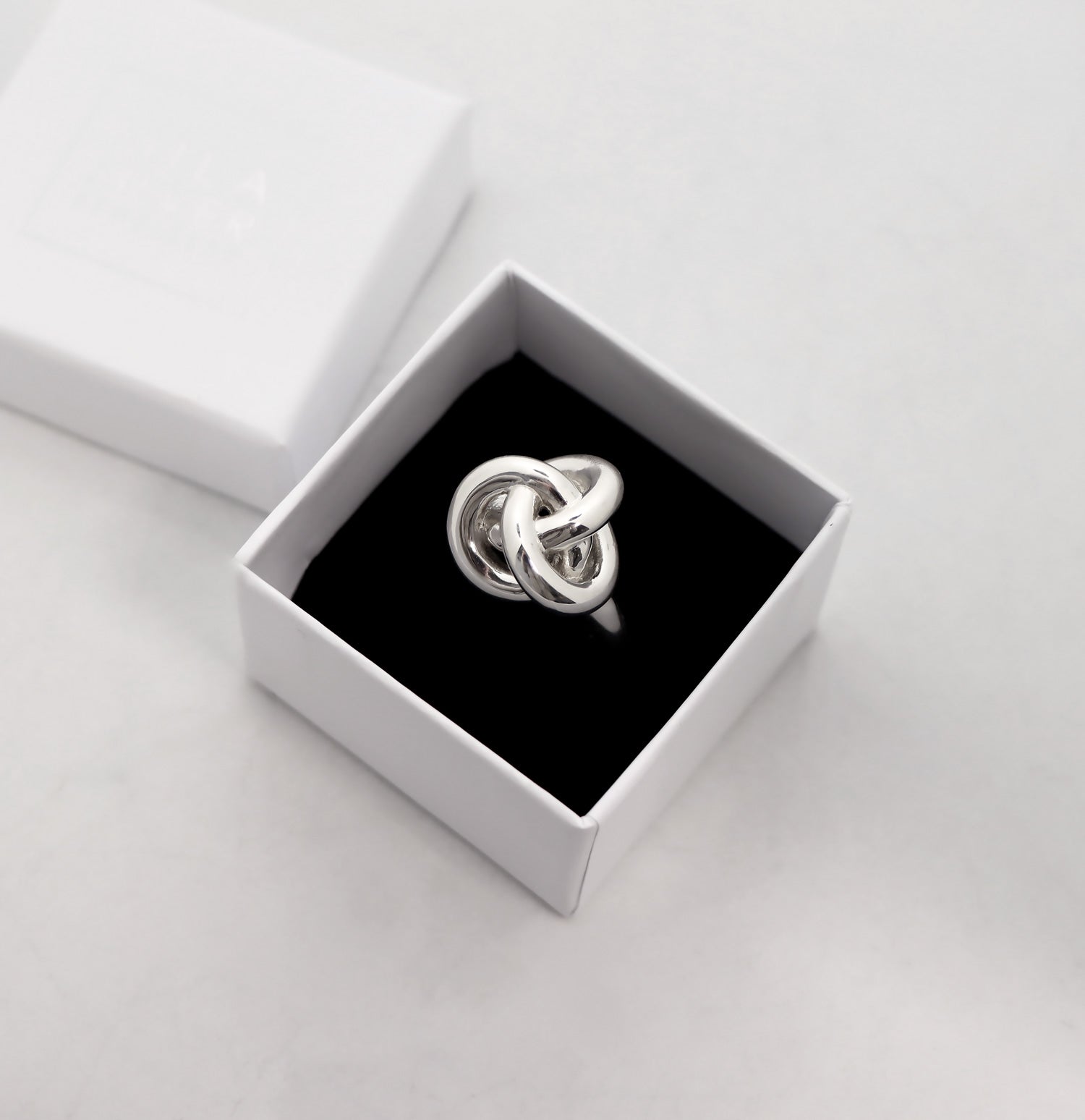 Ring med stor silverknut placerad i en vit ringask frÄn Mila Silver