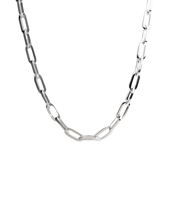 Silverkedja med ovala länkar som har kantiga profiler. Vit bakgrund.