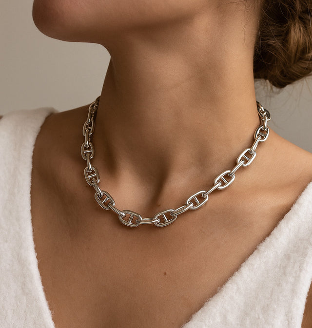 kvinna som bär ett brett kedjehalsband i silver, modell Ankar kedja