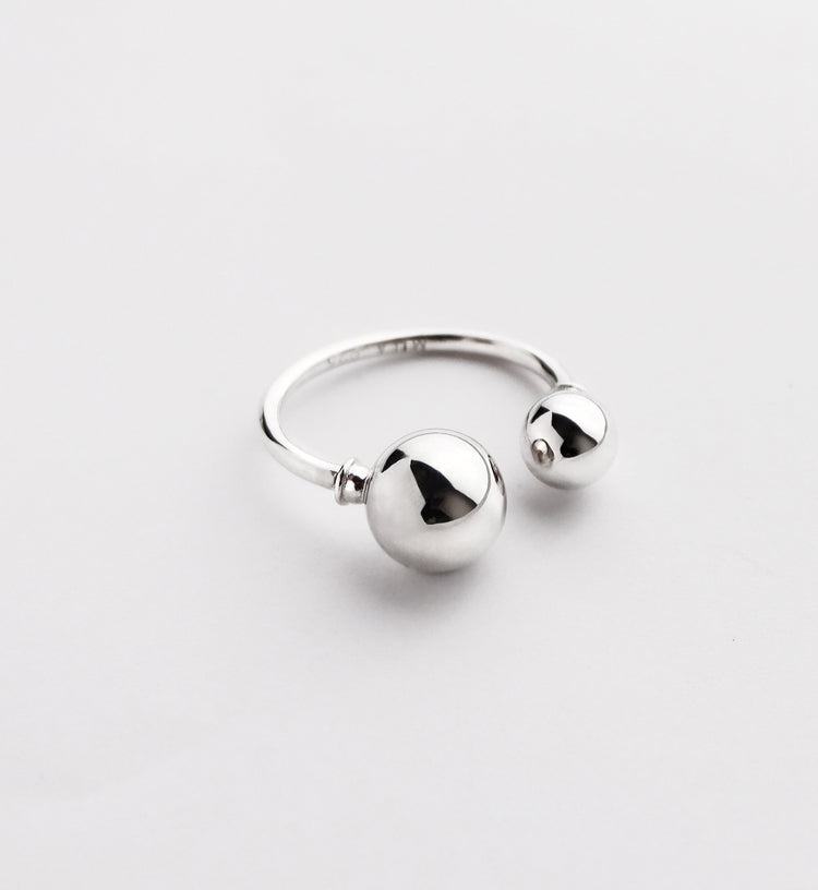 Silverring som är öppen med en stor och en liten silverkula.