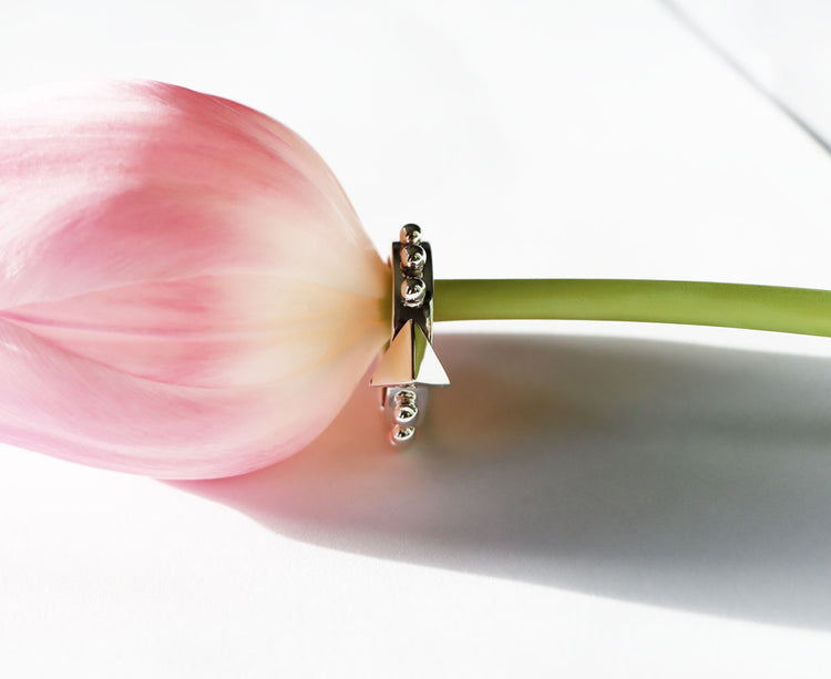 Silverring med en stor nit / pyramid som glänser, niten omsluts av små silverkulor.