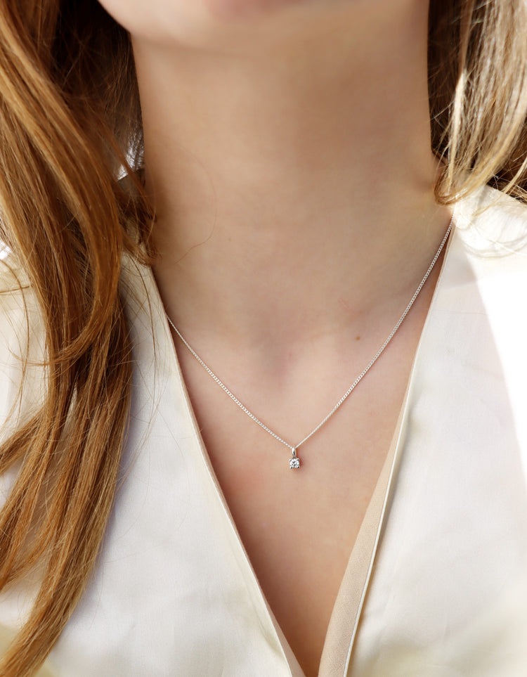 tjej som bär ett diamanthalsband i silver.