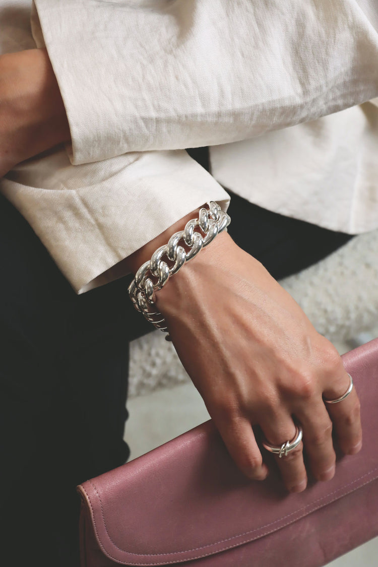 Tjej som bär ett brett kedje-armband i äkta silver.