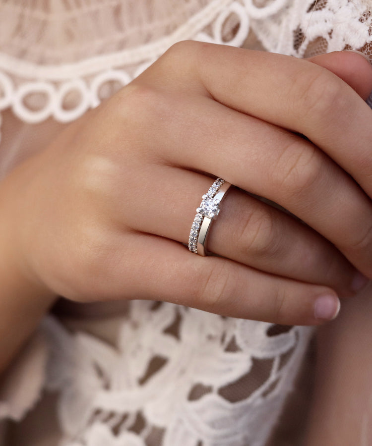 Tjej som bär ett set med vigselringar i vitguld med diamanter.