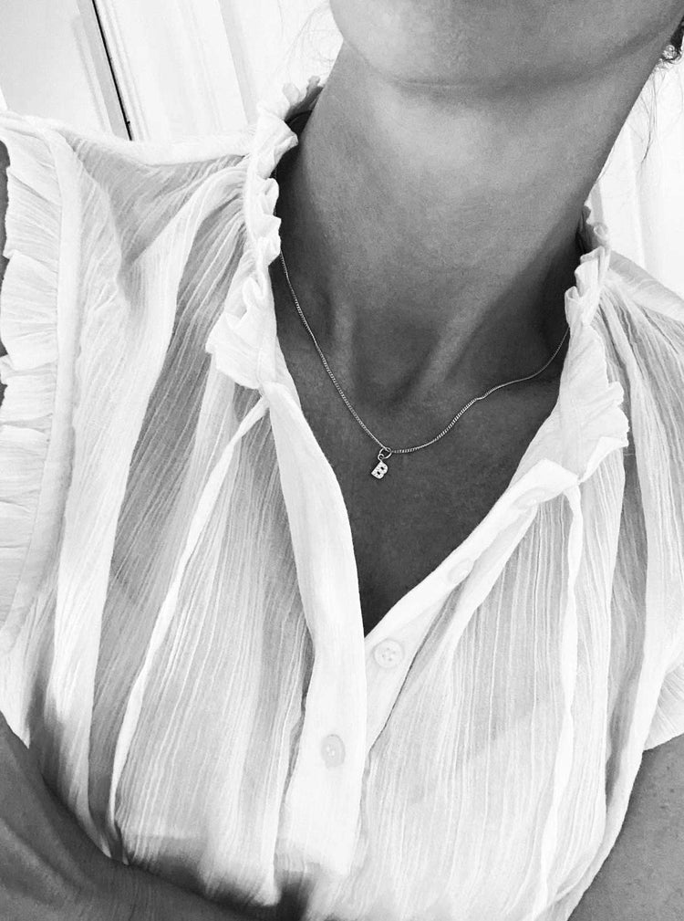 Halsband i silver med bokstavsberlock av diamanter.