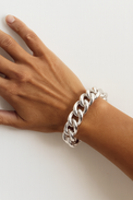 Tjej som bär ett chunky chain armband med stor pansarkedja i glänsande vitt 925 silver. 