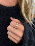 Diamantring och silverring i en ring stack som bärs på pekfingret