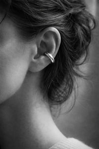 Tjej som bär en ear cuff i silver med stor tjock ring