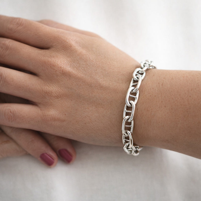 Kvinna som bär ett armband med silverkedja - modell bred Ankarkedja. 