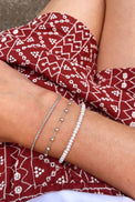 pärlarmband med små pärlor kombinerat med två tunna silverarmband.