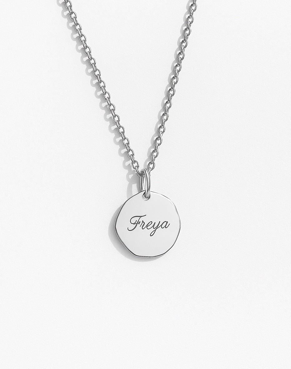 halsband i silver med graverat namn på berlock. 