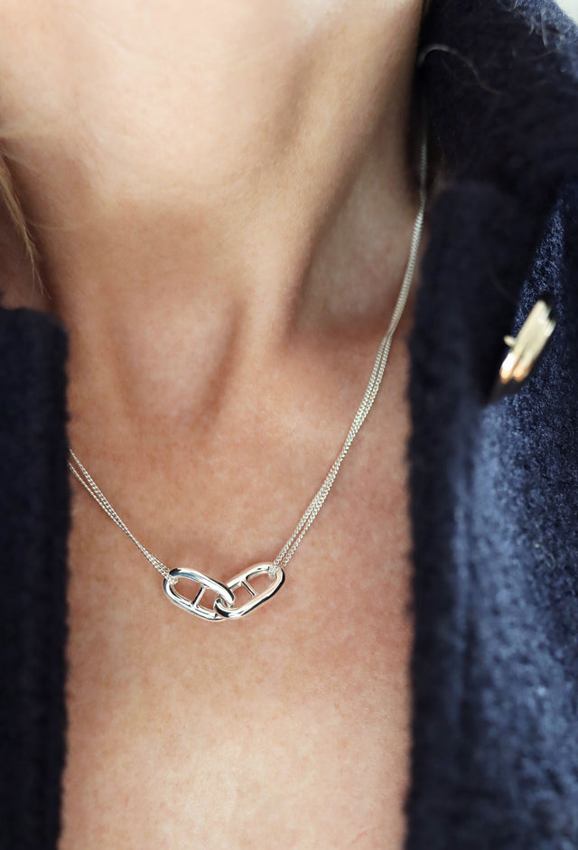 Tjej som bär ett kort silverhalsband med Ankarlänkar i kedja. 
