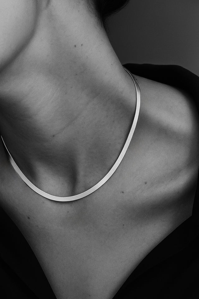 halsband med platt silverkedja som är kort. 