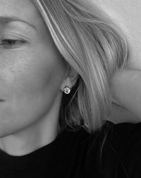 Tjej som bär stora knutar i öronen. 