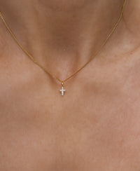 Halsband med ett litet diamantkors i guld. 