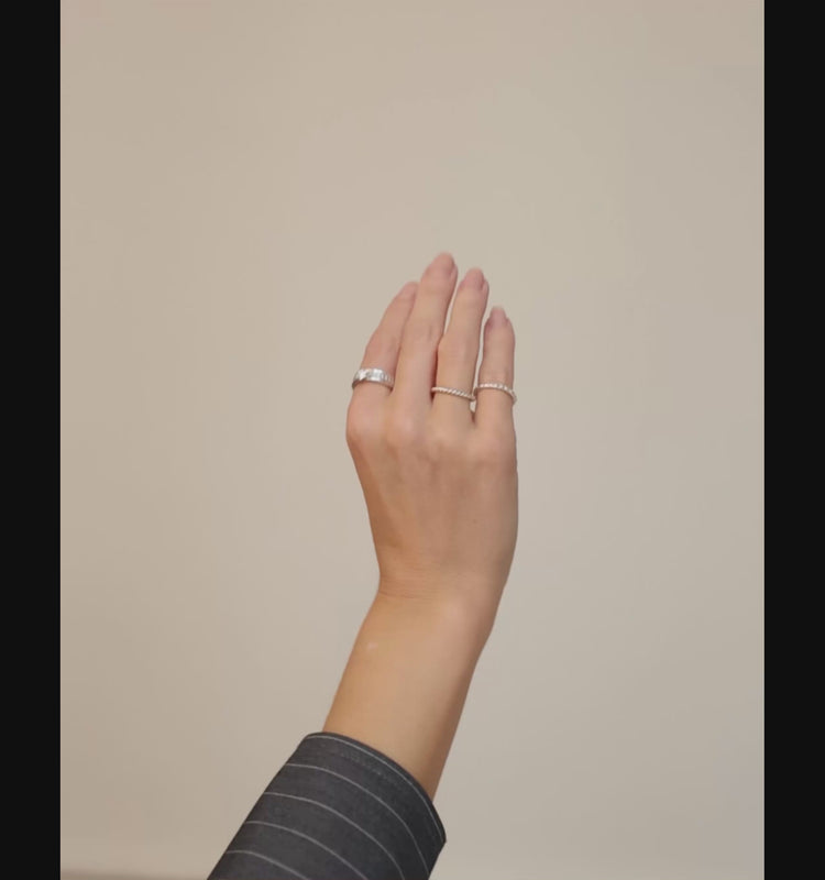 Tjej som bär flera diamantringar och silverringar på olika fingrar. 