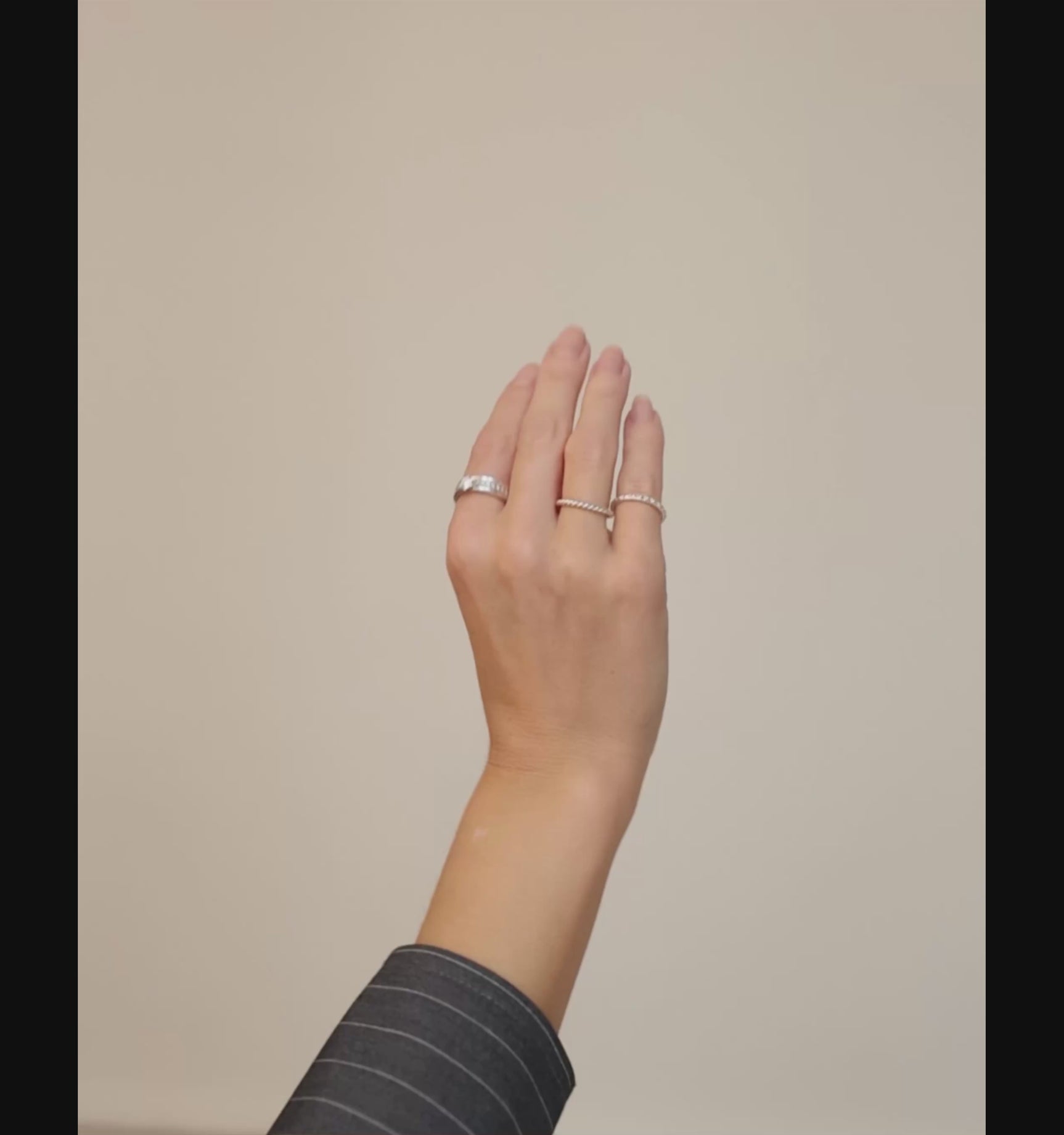 Tjej som bär flera diamantringar och silverringar på olika fingrar. 