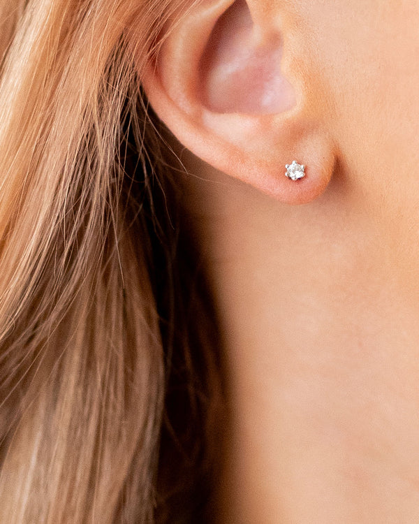 Women wearing diamond ear studs, 0,10 ct. 
