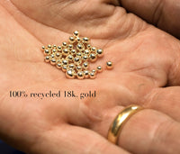 små kulor av återvunnet guld i en handflata