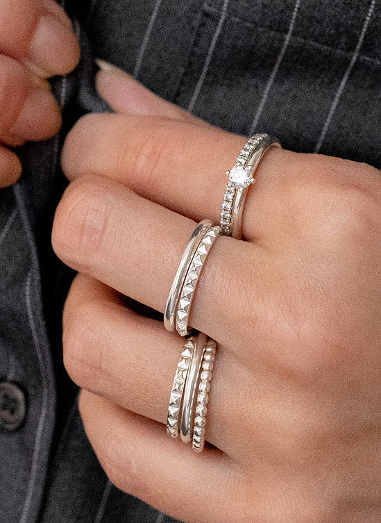 Silverringar och diamantringar i kombination utspridda på flera fingrar