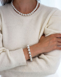 Tjej som bär armband och halsband med stora silverkulor