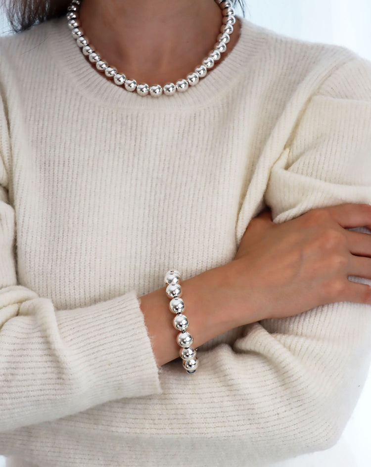 Tjej som bär armband och halsband med stora silverkulor