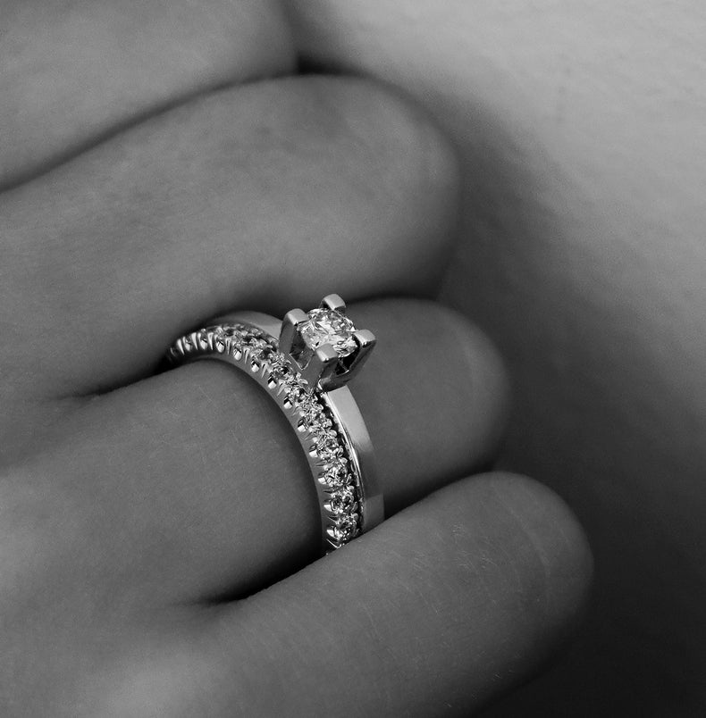 Tjej som bär ett set med diamantringar som vigsel och förlovningsringar. Diamantringar i silver med enstensring 0,25 ct och alliansring. 
